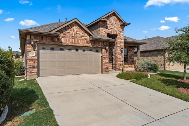 view of front of home featuring a garage, a front yard, concrete driveway, and brick siding