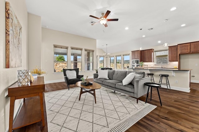 living room featuring ceiling fan with notable chandelier, wood finished floors, visible vents, and recessed lighting