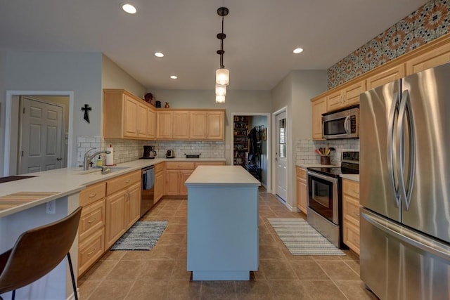 kitchen with light brown cabinets, stainless steel appliances, a sink, and light countertops