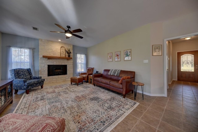 tiled living area with a healthy amount of sunlight, visible vents, a fireplace, and baseboards