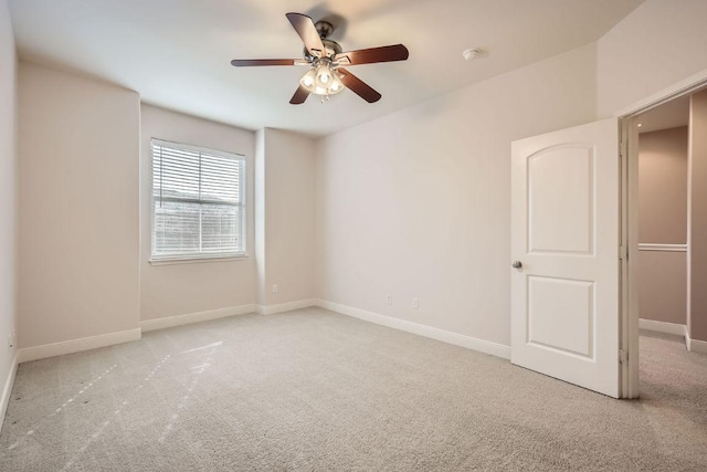 empty room with carpet floors, ceiling fan, and baseboards