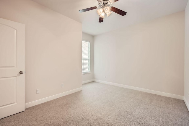 unfurnished room with light colored carpet, ceiling fan, and baseboards