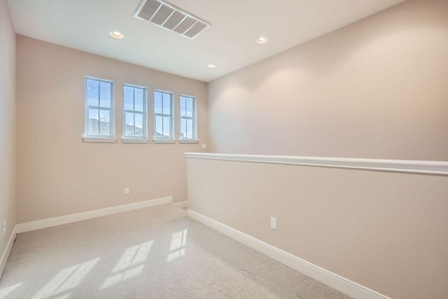 carpeted empty room featuring recessed lighting, visible vents, and baseboards