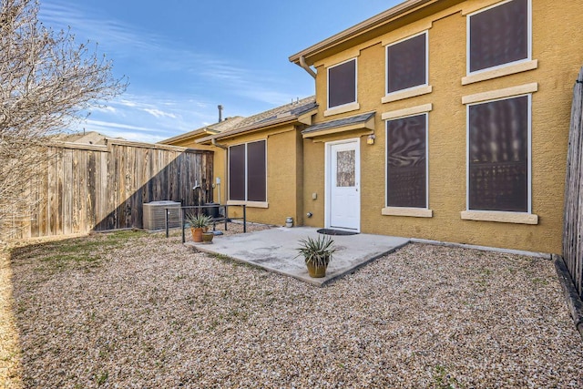 back of house with central air condition unit, a patio area, a fenced backyard, and stucco siding