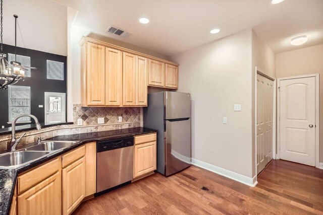 2210 Onion Creek Pkwy Unit 503, Austin, TX 78747 - kitchen with appliances with stainless steel finishes, a sink, light brown cabinetry, dark countertops, and recessed lighting