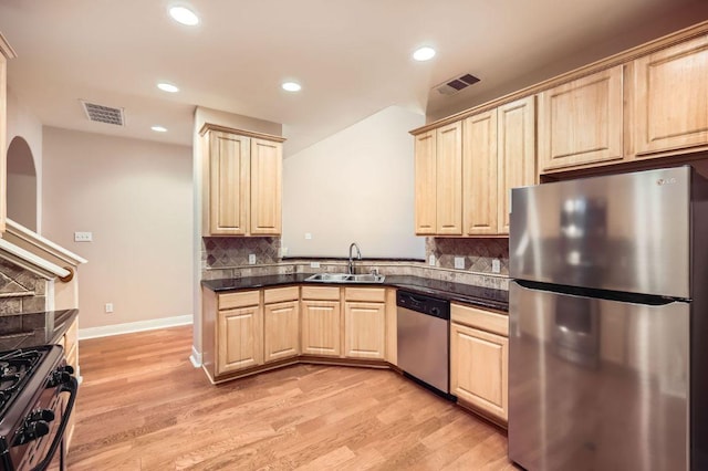 2210 Onion Creek Pkwy Unit 503, Austin, TX 78747 - kitchen featuring appliances with stainless steel finishes, a sink, light brown cabinetry, dark countertops, and light wood-style floors