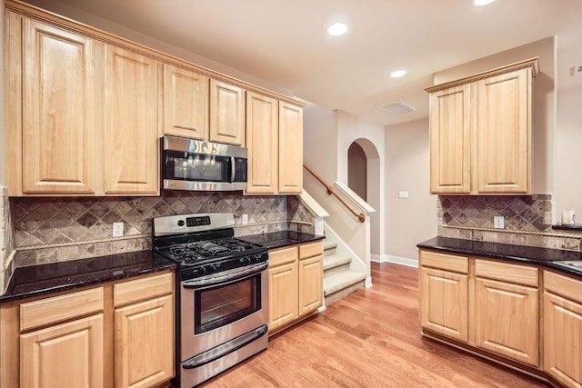 kitchen with stainless steel appliances, visible vents, baseboards, light brown cabinetry, and light wood finished floors