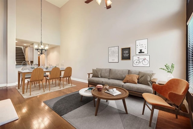 2210 Onion Creek Pkwy Unit 503, Austin, TX 78747 - living area featuring a towering ceiling, wood finished floors, a chandelier, baseboards, and a ceiling fan