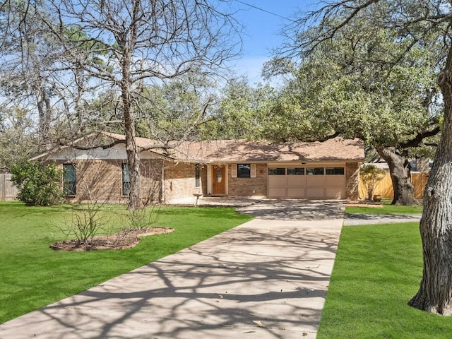 ranch-style home featuring brick siding, a front lawn, fence, concrete driveway, and an attached garage