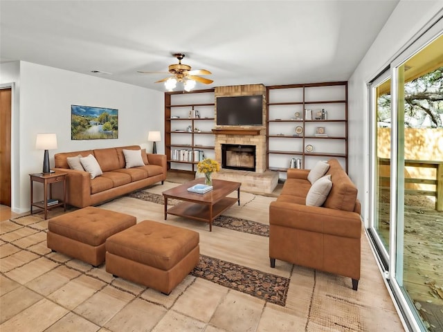 living room featuring visible vents, built in shelves, a ceiling fan, and a fireplace