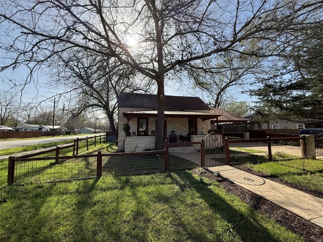 401 San Jacinto St, Smithville, TX 78957 - view of front of property with a front lawn, a gate, a fenced front yard, stone siding, and covered porch