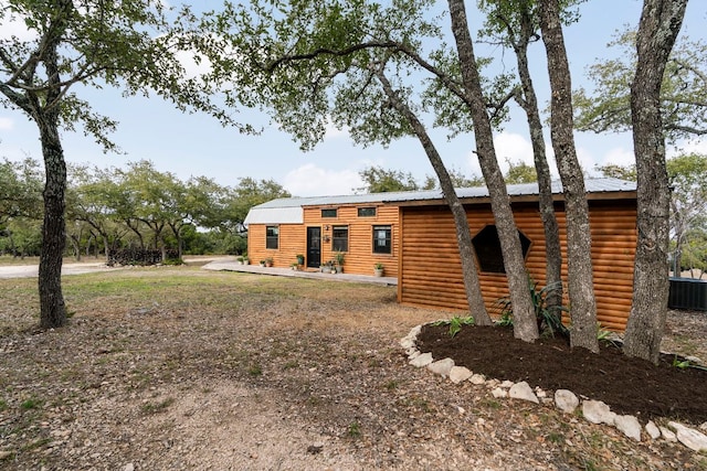 view of front of property featuring metal roof, cooling unit, and faux log siding