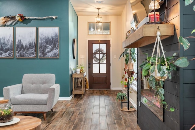 foyer entrance with wood finished floors, visible vents, and baseboards