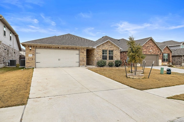 single story home featuring concrete driveway, central AC unit, an attached garage, and brick siding