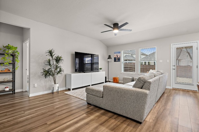 living area with ceiling fan, baseboards, wood finished floors, and lofted ceiling