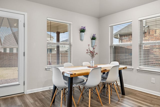 dining area with a wealth of natural light, baseboards, and wood finished floors