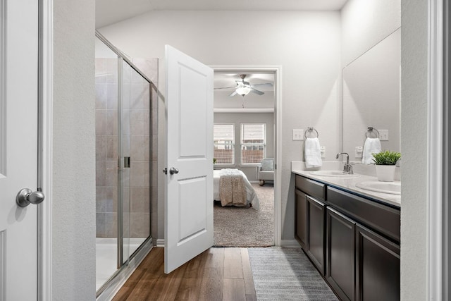 bathroom with double vanity, a sink, a shower stall, and ensuite bathroom