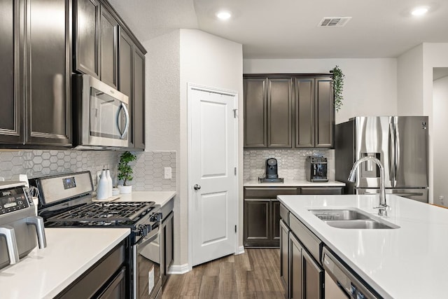 kitchen with visible vents, stainless steel appliances, a sink, and light countertops