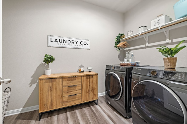 washroom with laundry area, wood finished floors, and washing machine and dryer