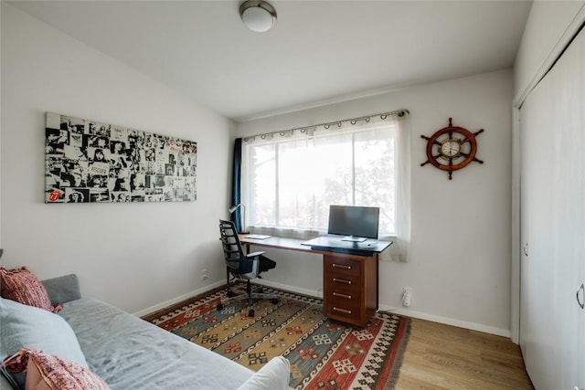 office featuring vaulted ceiling, wood finished floors, and baseboards