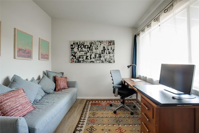 home office featuring vaulted ceiling, wood finished floors, and baseboards