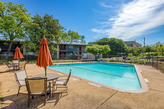 community pool featuring a patio and fence