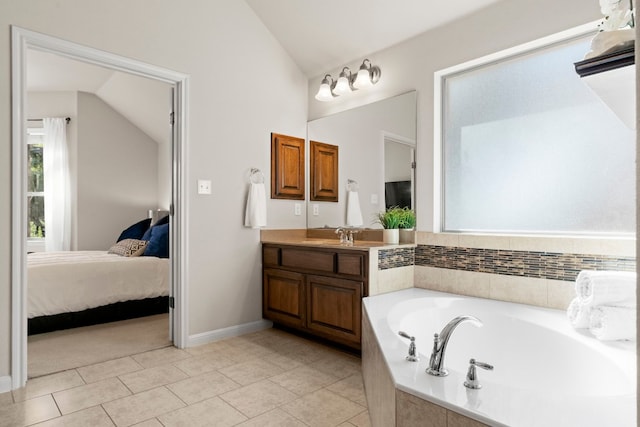 full bathroom with lofted ceiling, ensuite bathroom, a garden tub, vanity, and tile patterned floors