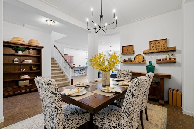 dining area with ceiling fan with notable chandelier, dark tile patterned flooring, stairway, and crown molding