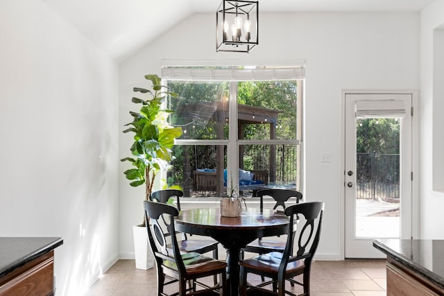 dining room featuring lofted ceiling, an inviting chandelier, baseboards, and light tile patterned flooring