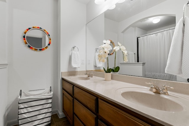 bathroom with tile patterned flooring, a sink, and double vanity