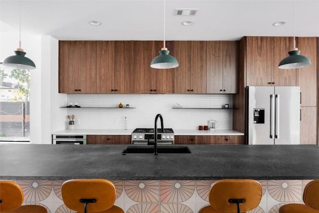 kitchen featuring visible vents, appliances with stainless steel finishes, a breakfast bar, and decorative backsplash