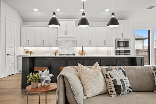 kitchen with stainless steel appliances, open floor plan, visible vents, and decorative backsplash