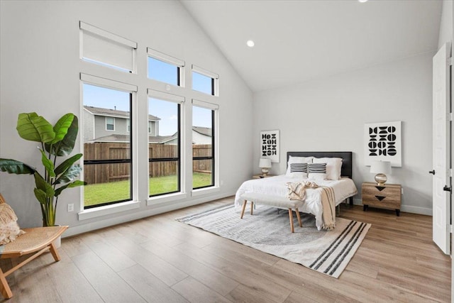 bedroom featuring high vaulted ceiling, recessed lighting, light wood-style flooring, and baseboards