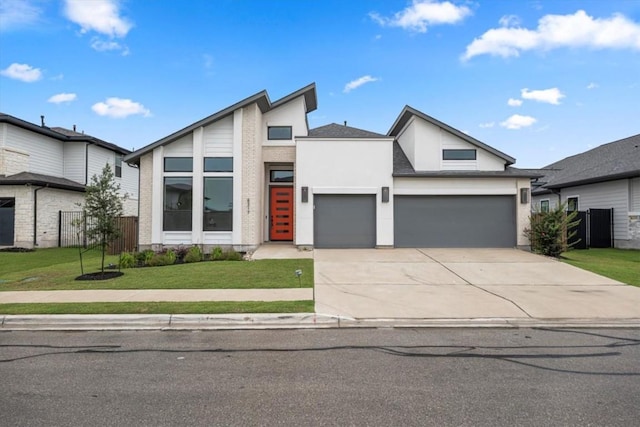 view of front of house featuring stucco siding, concrete driveway, an attached garage, fence, and a front lawn