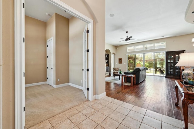 114 Hazelnut Ct, Driftwood, TX 78619 - carpeted living area with ceiling fan, arched walkways, tile patterned floors, and baseboards