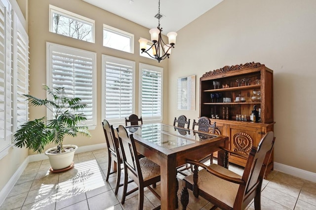 114 Hazelnut Ct, Driftwood, TX 78619 - dining area featuring a chandelier, baseboards, a high ceiling, and light tile patterned flooring