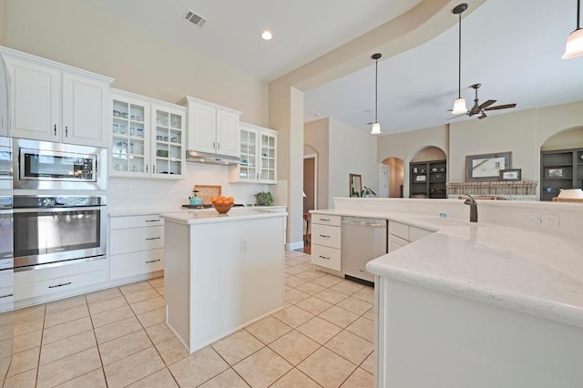 114 Hazelnut Ct, Driftwood, TX 78619 - kitchen with stainless steel appliances, arched walkways, a sink, a center island, and ceiling fan