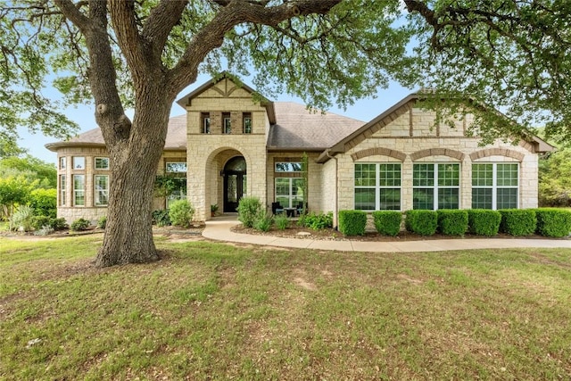 114 Hazelnut Ct, Driftwood, TX 78619 - view of front of property with stone siding, a front yard, and roof with shingles