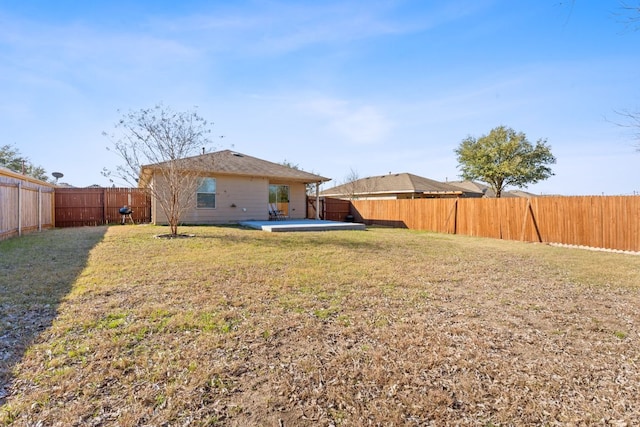 back of house featuring a fenced backyard, a patio, and a yard