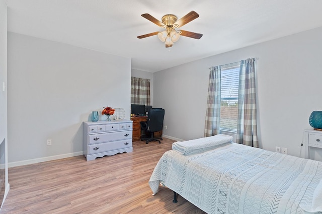 bedroom with a ceiling fan, light wood-style flooring, and baseboards