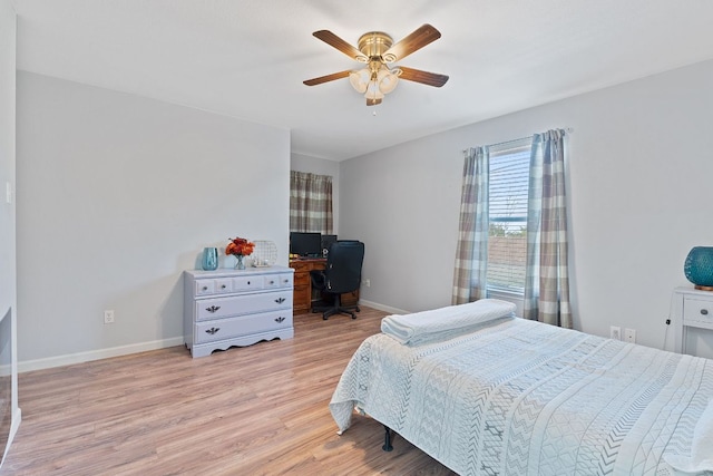 bedroom with light wood-type flooring, baseboards, and a ceiling fan