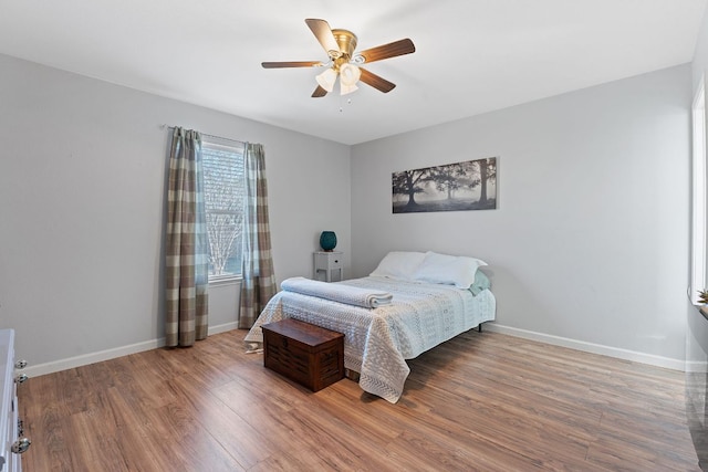bedroom featuring wood finished floors, baseboards, and a ceiling fan