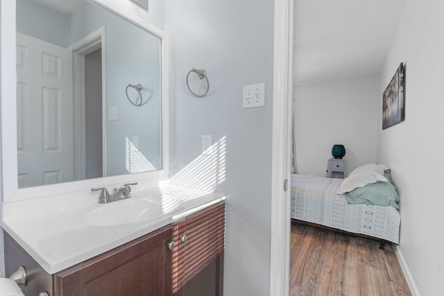 bathroom with vanity, baseboards, and wood finished floors