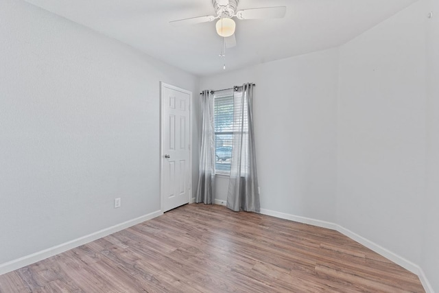 empty room with light wood-type flooring, ceiling fan, and baseboards