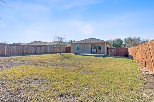 back of property with a fenced backyard, a lawn, and a patio