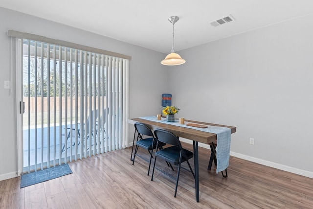 dining area with visible vents, baseboards, and wood finished floors