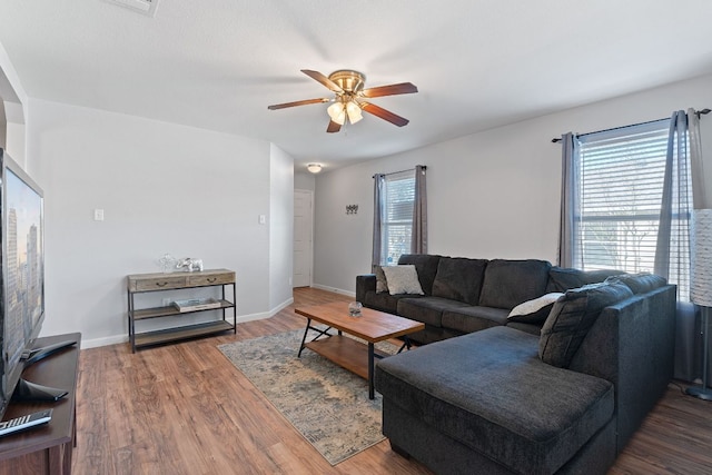 living room featuring wood finished floors, ceiling fan, and baseboards