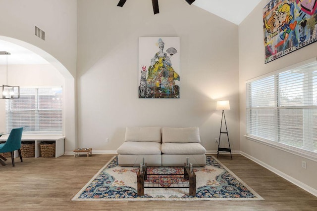 living area featuring high vaulted ceiling, a wealth of natural light, wood finished floors, and visible vents