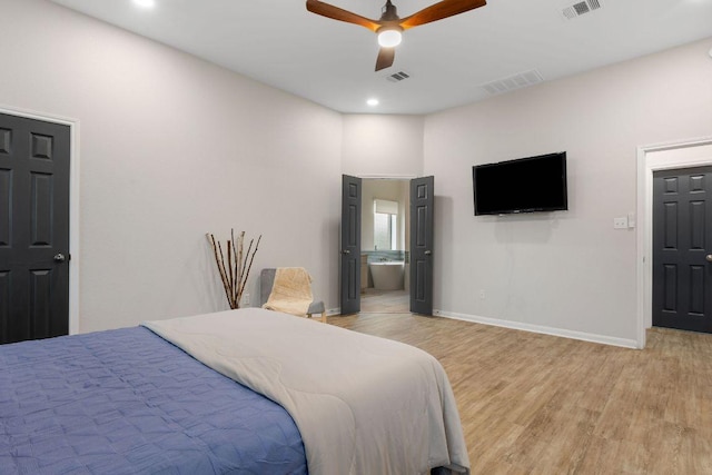 bedroom featuring light wood-style flooring, connected bathroom, visible vents, and baseboards