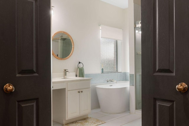 full bathroom featuring a soaking tub, tile patterned floors, tile walls, and vanity